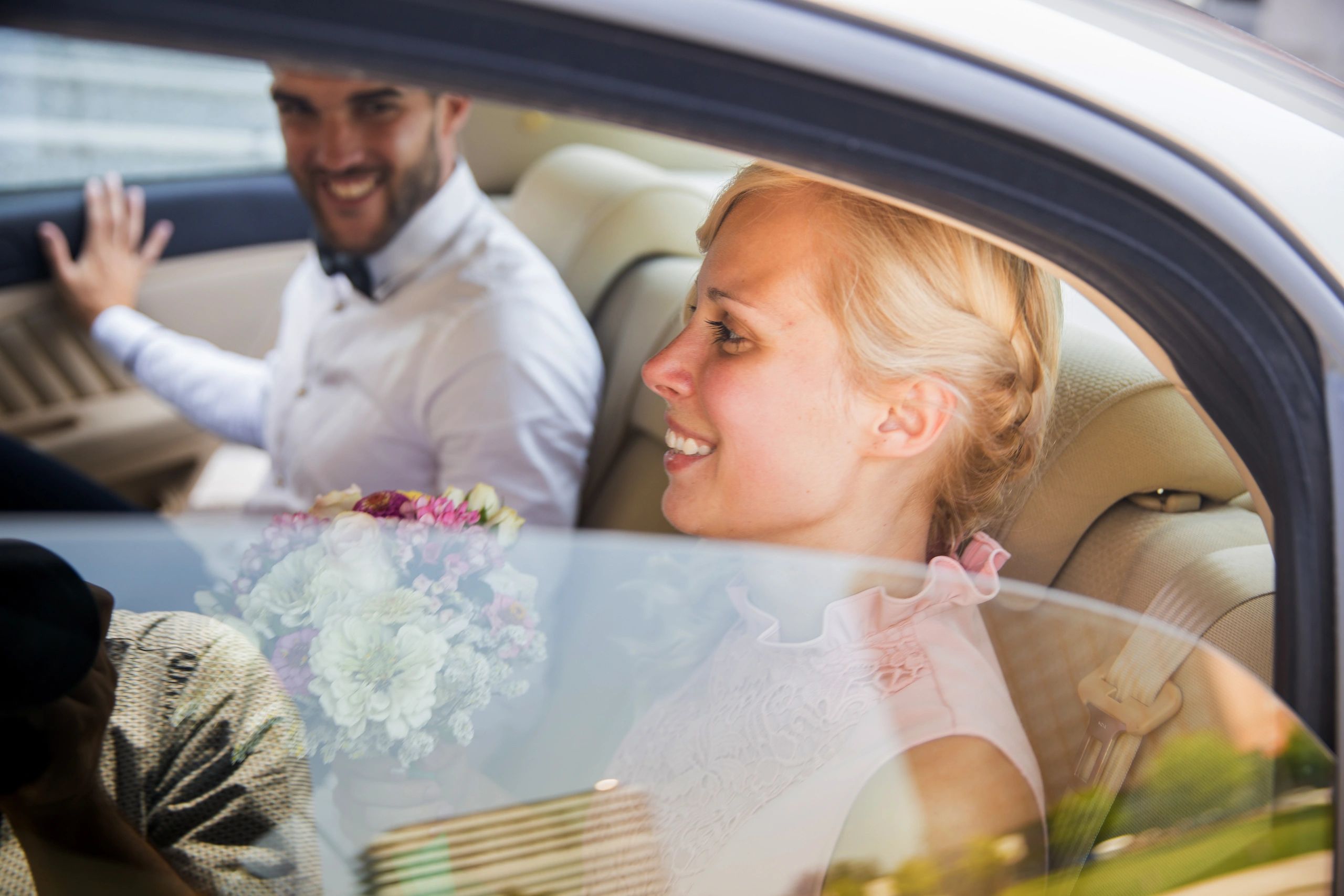Just married couple riding in a luxury car
